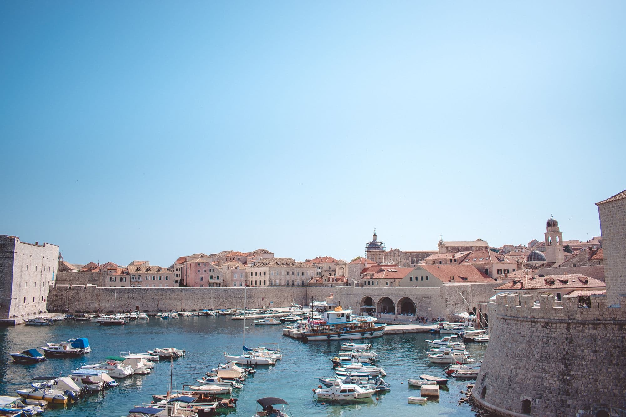 Charming view of the historic harbor in Dubrovnik, Croatia, with boats and medieval architecture