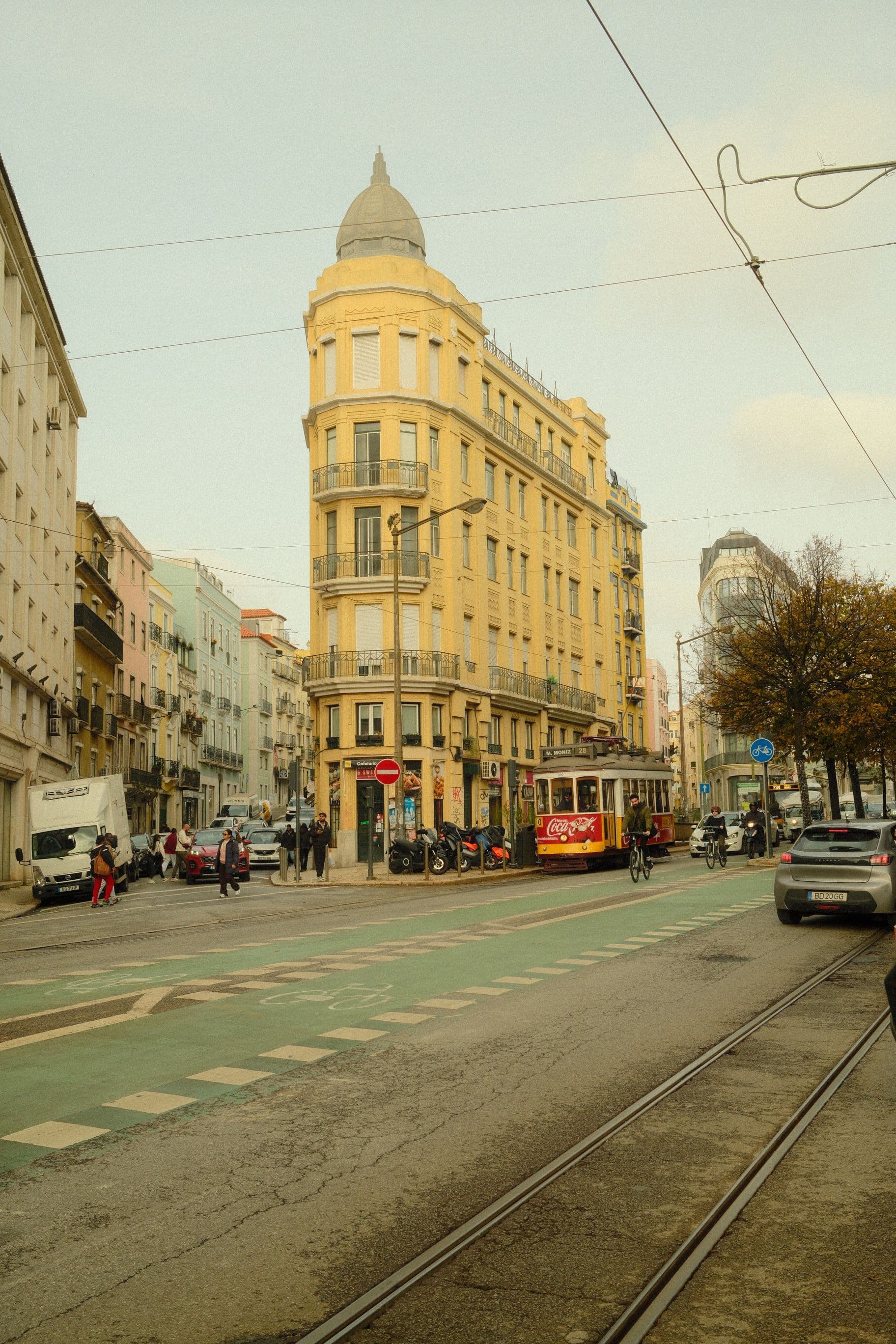 Vibrant street scene of Lisbon featuring classic yellow tram and distinctive architecture